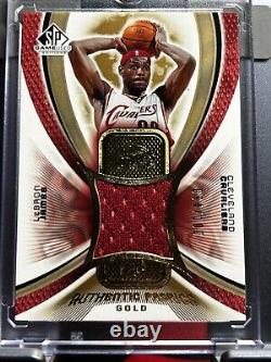 2005 SP Game Used LeBron James Cavaliers Cavs Authentic Fabrics Gold /100 Mint translated in French would be: 2005 SP Game Used LeBron James Cavaliers Cavs Tissus Authentiques Or /100 Mint.
